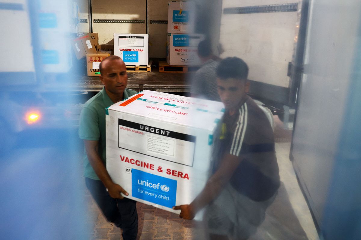 Workers unload a shipment of polio vaccines provided with support from UNICEF to the Gaza Strip through the Karm Abu Salem crossing, also known as Kerem Shalom, at a depot belonging to Gaza's health ministry on August 25, 2024, amid the ongoing conflict in the Palestinian territory between Israel and the Palestinian militant group Hamas. (EYAD BABA/AFP via Getty Images)