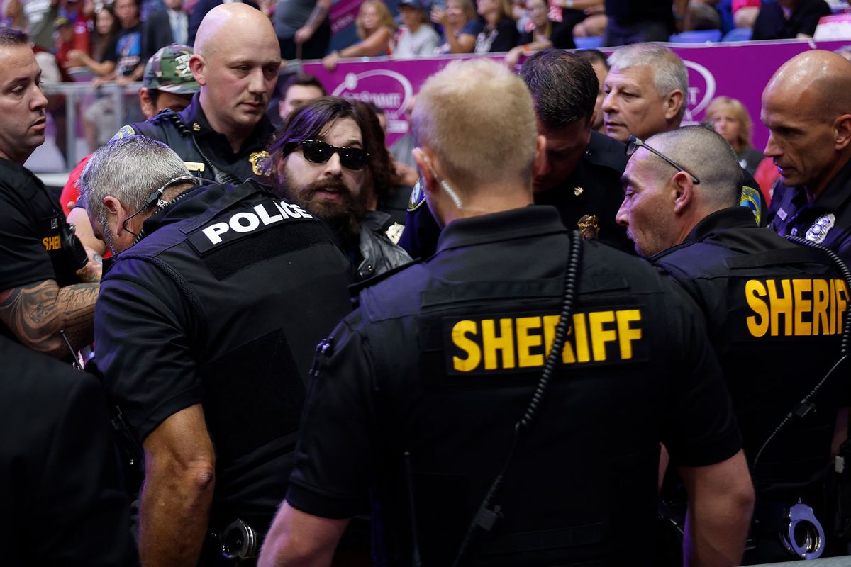 A protester (center in sunglasses) is arrested by law enforcement officers after jumping onto the media platform at a campaign rally for Republican presidential nominee, former U.S. President Donald Trump at the 1st Summit Arena on August 30, 2024 in Johnstown, Pennsylvania. (Chip Somodevilla/Getty Images)