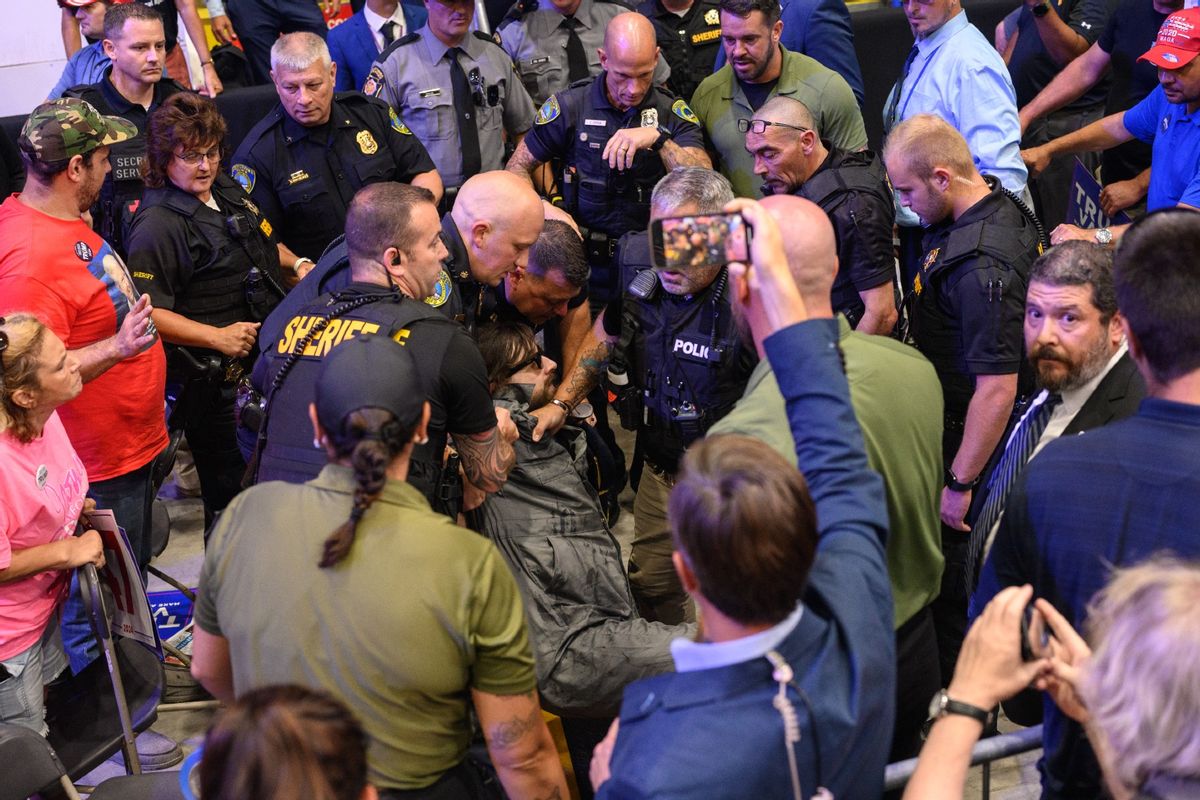 A man is apprehended by security and police after jumping onto the media platform at a campaign rally for Republican presidential nominee, former U.S. President Donald Trump at the 1st Summit Arena on August 30, 2024 in Johnstown, Pennsylvania. (Justin Merriman/Getty Images)